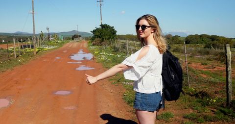 Woman Hitchhiking on Scenic Rural Road - Download Free Stock Images Pikwizard.com