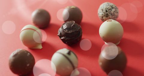 Chocolate Pralines on Red Background with Textured Lighting