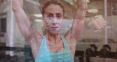 Female athlete performing overhead dumbbell press with stock market data double exposure