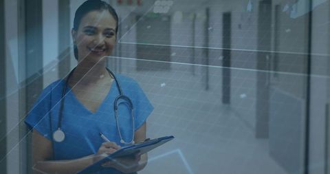 Nurse Reviewing Data in Hospital Corridor with Clipboard