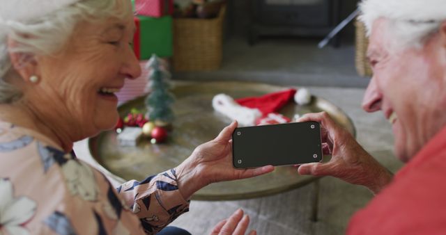 Senior Couple Laughing While Looking at Smartphone during Christmas Holiday - Download Free Stock Images Pikwizard.com