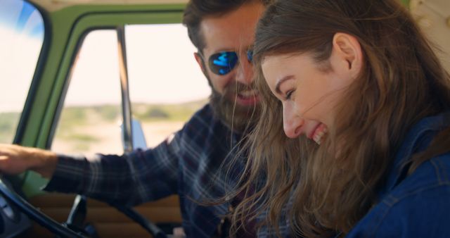 Couple smiling and laughing inside a vintage car during a sunny road trip adventure. Perfect for depicting travel, fun, lifestyle, vacations, and carefree moments. Ideal for websites, travel agencies, lifestyle blogs, and advertisement campaigns promoting joy and spontaneity.