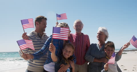Joyful Multigenerational Family Holding Flags on Sunny Beach