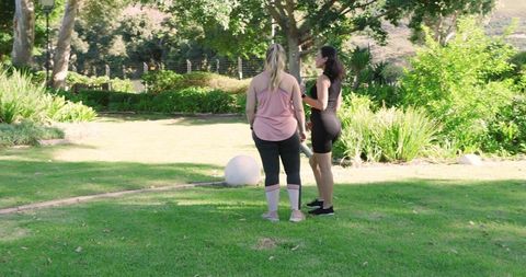Two Friends Engaging in Outdoor Fitness Conversation in Park
