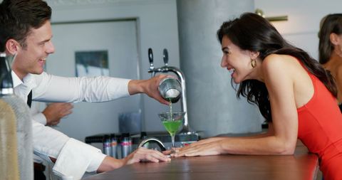 Bartender Pouring Cocktail for Smiling Customer at Counter - Download Free Stock Images Pikwizard.com