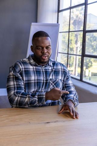 Confident businessman emphasizing time at modern workplace