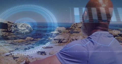 Mature man overlooking rocky coastline with futuristic hud overlay and analytics