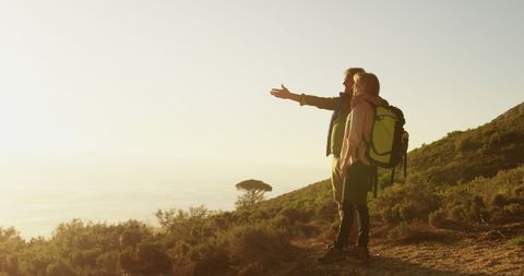 Senior Couple Hiking at Sunset Enjoying Scenic View