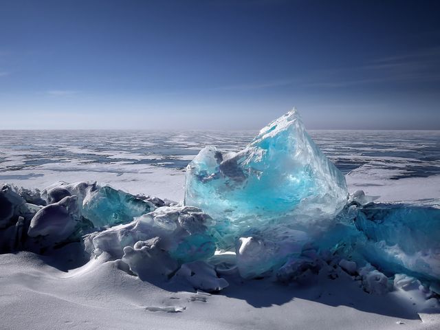 Mountained ice block on frozen Arctic tundra on clear blue sky day - Download Free Stock Photos Pikwizard.com