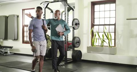 Personal fitness trainer coaching athlete in modern gym environment