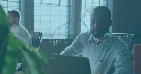 Businessman Analyzing Stock Market Data on Laptop in Modern Office