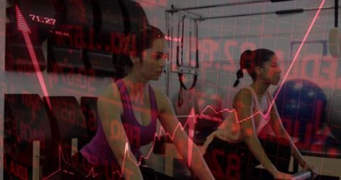 Female Friends Pedaling on Stationary Bikes with Red Stock Market Overlay Conveying Drive