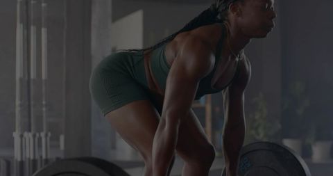 Woman deadlifting heavy barbell in gym, lifting for strength and athletic training