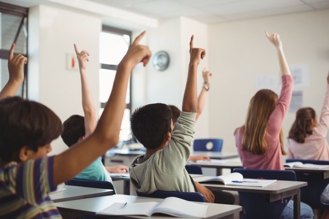 School kids raising hand in classroom - Download Free Stock Photos Pikwizard.com