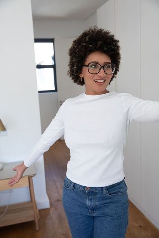 Joyful african american woman stretching arms at home