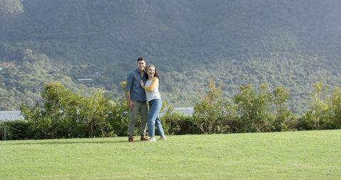 Happy Couple Enjoying Nature at Forested Mountain Base