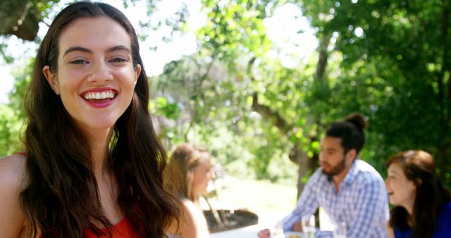 Happy Young Woman Enjoying Outdoor Gathering with Friends - Download Free Stock Images Pikwizard.com