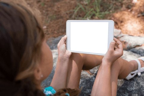 Transparent Screen Digital Tablet Held by Girl in Forest Setting