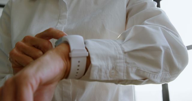 Closeup of Person in White Shirt Adjusting Smartwatch Wristband - Download Free Stock Images Pikwizard.com
