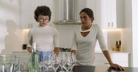 Two Women Preparing Tableware in Modern Kitchen Conversation