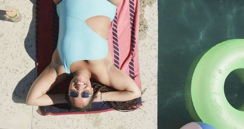 Young Woman Relaxing Poolside in Blue Swimsuit