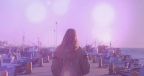 Woman Facing Vibrant Sunrise Over Fishing Harbor