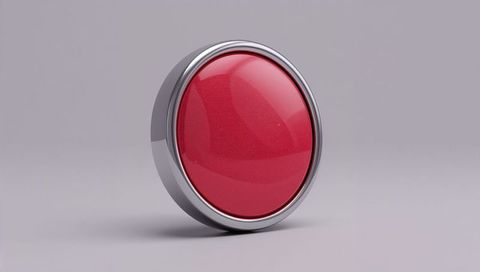 Glossy red push button shining on neutral gray surface with chrome bezel