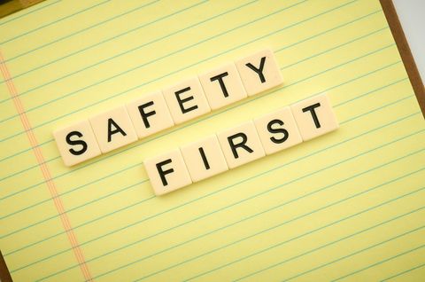 Safety first concept with letter tiles on notebook paper