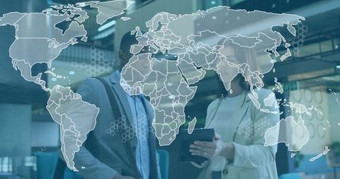 Business professionals holding tablet with world map overlay for global collaboration