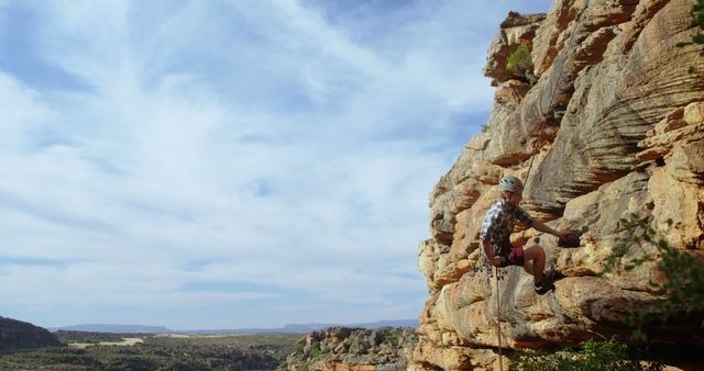 Adventurer Climbing Rocky Cliff in Scenic Desert Landscape - Download Free Stock Images Pikwizard.com