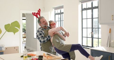 Senior Couple Celebrating in Cozy Kitchen with Playful Antics