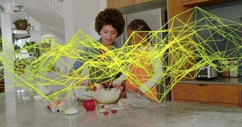Mother and daughter mixing batter on marble island with neon yellow data network overlay