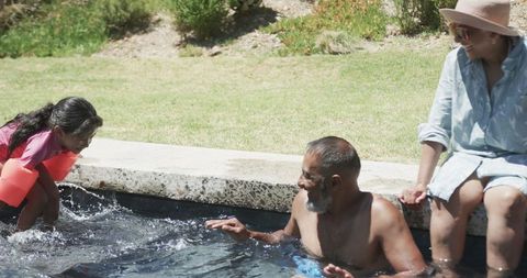 Family Fun in Backyard Pool on Sunny Day