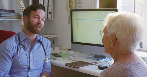 Doctor Consulting Senior Woman Wearing Glasses in Clinic Office Setting