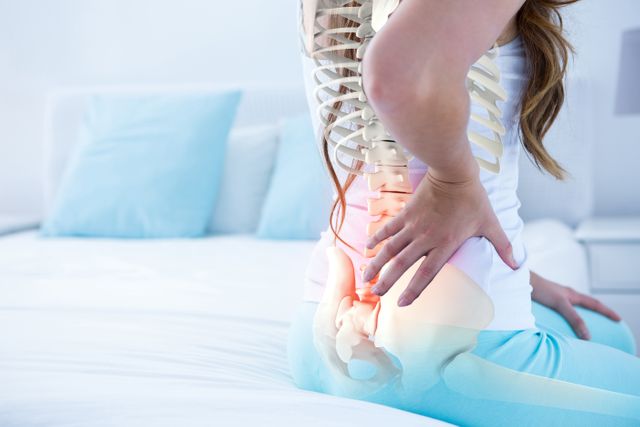 This stock photo shows a woman seated on a bed with a digital composite of her highlighted spine, emphasizing back pain. Useful for health-related articles, medical websites, pain relief products, and informational content on orthopedic issues.