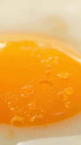 Revealing Glossy Egg Yolk Close-Up with Droplets Vertical Macro Food Video