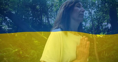 Woman Praying Outdoors with Ukraine Flag Overlay