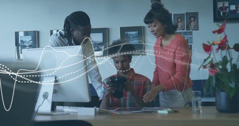 Diverse Team Collaborating Over Digital Device in Office