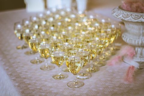 Rows of white wine glasses lining buffet table for elegant wedding reception