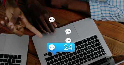 Hands pointing on laptop trackpad with chat notification badge 24 for team collaboration