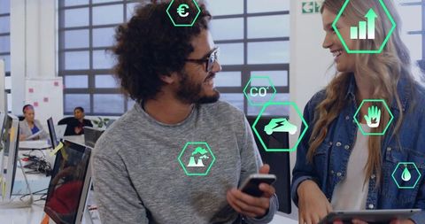 Coworkers collaborating on tablet and phone in sustainable office with analytics icons
