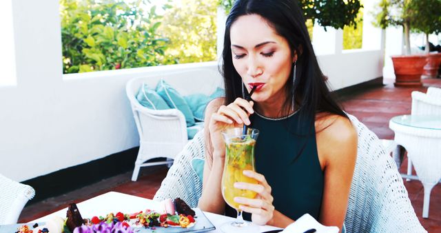 Woman sipping tropical drink at outdoor cafe - Download Free Stock Images Pikwizard.com