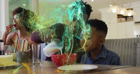 Cozy family breakfast pouring milk into red bowl while child watches at table, candid morning warmth