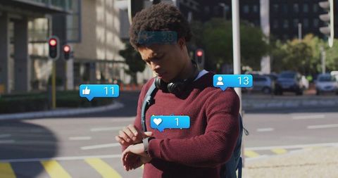 Young Man Checks Smartphone Notifications On City Street With Headphones