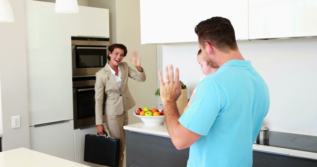 Businesswoman waving goodbye to family in modern kitchen - Download Free Stock Images Pikwizard.com