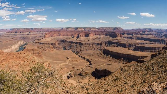 Vast red rock canyon panorama with winding river, layered mesas and desert gorge