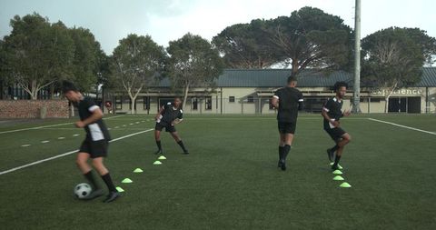 Soccer players practicing dribbling drills on training field
