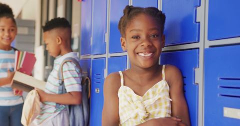 Smiling african american schoolgirl by lockers