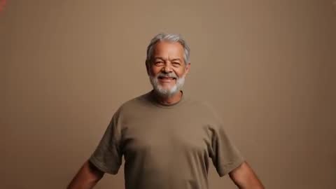 Smiling senior man posing with arms extended, lowering arms to sides, studio portrait
