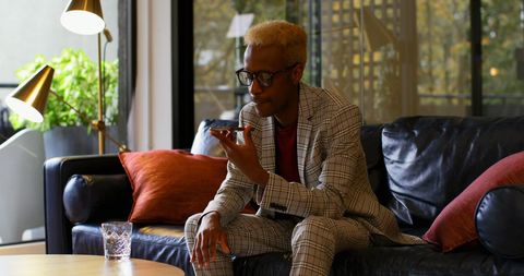 Young businessman on phone in modern office lounge